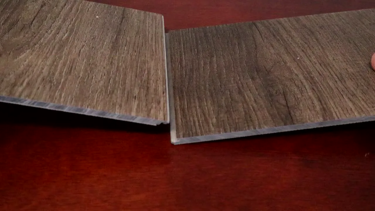 WPC and SPC vinyl plank samples side by side on a table, their cut ends showing the thicker WPC core and the thinner, denser SPC core